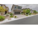 Charming two-story home with a gray facade, two-car garage, and low-maintenance landscaping at 5927 Coja St, Las Vegas, NV 89113