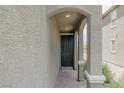 Inviting front door under an arched portico, framed by decorative columns and textured walls at 5927 Coja St, Las Vegas, NV 89113
