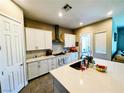 Well-equipped kitchen featuring white cabinets, modern appliances, and a spacious center island with a sink at 6021 Vivanco St, North Las Vegas, NV 89081