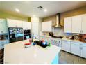 Bright kitchen featuring white cabinets, stainless steel appliances, and a large center island at 6021 Vivanco St, North Las Vegas, NV 89081
