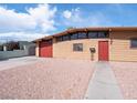 Tan home with a red garage door and a red front door at 6112 Fairwood Cir, Las Vegas, NV 89107