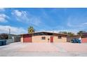 Charming home with a desert landscape featuring a red door and garage at 6112 Fairwood Cir, Las Vegas, NV 89107