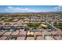 Aerial view of a house in a suburban neighborhood with a view of the surrounding landscape at 7694 Hampton Park Ln, Las Vegas, NV 89113