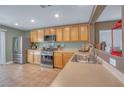 Functional kitchen with stainless steel appliances, light wood cabinetry, and tiled floors at 8320 Highland Ranch St, Las Vegas, NV 89131