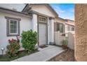 Inviting front entrance with manicured bushes, grey trim, and a welcoming front door at 8389 Charlton Valley Ct, Las Vegas, NV 89123