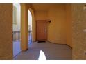 Covered entryway with an arched doorway and decorative wall sconce at 9209 Tudor Park Pl, Las Vegas, NV 89145