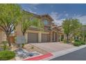 Beautiful two-story home with a stone accent, manicured landscaping, and brick paved driveway and three-car garage at 9792 Crescent Lodge Ct, Las Vegas, NV 89178