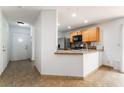 Bright kitchen featuring a breakfast bar, stainless steel appliances, and tile floors at 9962 Keephills St, Las Vegas, NV 89183