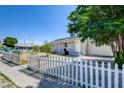 Quaint one-story house featuring a white picket fence, grassy area, and tree for curb appeal at 1123 Chapman Dr, Las Vegas, NV 89104