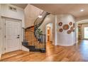 Inviting foyer features a curved staircase, hardwood floors, and an elegant chandelier at 1235 Panini Dr, Henderson, NV 89052