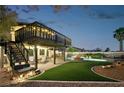 Expansive backyard featuring a two-story deck, artificial turf, pool with spa and ample seating area at 1251 Los Meadows Dr, Las Vegas, NV 89110