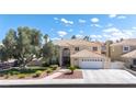 Beautiful two-story home featuring manicured landscaping, a spacious driveway, and a charming front entrance at 1502 Oxbow Ct, Henderson, NV 89014