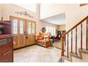 Elegant foyer with a striking staircase, tile flooring, and a decorative front door creating a welcoming entrance at 1502 Oxbow Ct, Henderson, NV 89014