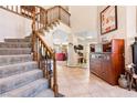 Spacious foyer featuring a carpeted staircase, tile flooring, and an open layout to the living areas at 1502 Oxbow Ct, Henderson, NV 89014