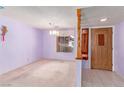 Living room featuring light purple walls, carpeted floors, and a large window providing natural light at 1513 Brocado Ln, Las Vegas, NV 89117