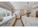 Bright, spacious kitchen featuring white cabinetry, quartz counters, stainless appliances, and decorative lighting at 1624 Ravanusa Dr, Henderson, NV 89052
