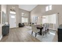 Bright living room with wood-look tile flooring, dining area, high ceilings, and large windows for ample natural light at 1780 Crystal Stream Ave, Henderson, NV 89012