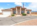 Attractive single-story home boasting desert landscaping, arched windows, RV parking, and an American flag at 2020 S Omaha Ave, Pahrump, NV 89048