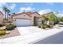 Inviting single-story home featuring a two-car garage and mature palm trees in the front yard at 203 Sea Rim Ave, Las Vegas, NV 89148