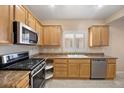 Bright kitchen featuring wooden cabinets, granite countertops, and stainless steel appliances at 2117 Bay Thrush Way, North Las Vegas, NV 89084
