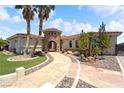 Stunning home featuring a stone tower entrance, palm trees, tile roof, and beautifully landscaped front yard at 2181 E Winery Rd, Pahrump, NV 89048