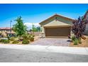 Two car garage with a stone veneer trim and desert landscaping at 3484 Bradano Ln, Henderson, NV 89044