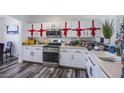 Bright kitchen featuring white cabinets with red ribbon decor and stainless steel appliances at 4429 E Azure Ave, Las Vegas, NV 89115