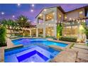 Luxury backyard with beautiful pool and attached spa, string lights for evening enjoyment at 454 Rosina Vista St, Las Vegas, NV 89138