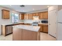 Traditional kitchen featuring wood cabinetry, white appliances and white tile countertops, backsplash and island at 4744 Deer Forest Ave, Las Vegas, NV 89139
