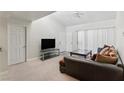 Bright living room featuring neutral walls and carpet, a large sofa, and a sliding glass door at 5166 S Jones Blvd # 205, Las Vegas, NV 89118