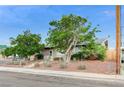 Front view of a single-story home, featuring desert landscaping and a chain-link fence at 601 Huntington St, Las Vegas, NV 89107