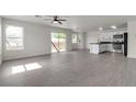 Open-concept living room with sliding door access to the backyard, adjacent to the modern kitchen at 6117 Daisy Lee Ave, Las Vegas, NV 89108
