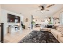 Bright and open living room with tile flooring, ceiling fan, and contemporary decor with a large TV for entertaining at 7928 Violet Dawn St, Las Vegas, NV 89149