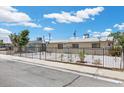 View of the front of a home with a metal gate, concrete driveway, and white gravel landscaping at 808 Reynolds Ave, North Las Vegas, NV 89030