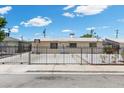 Home with a gated driveway, offering security and privacy, enhanced by white gravel landscaping elements at 808 Reynolds Ave, North Las Vegas, NV 89030
