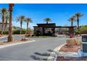 A modern gatehouse with stone accents and mature palm trees welcomes residents to this luxurious community at 8564 Mayport Dr, Las Vegas, NV 89131