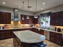 Gourmet kitchen boasts dark wood cabinets, granite countertops, and a large center island with seating at 8564 Mayport Dr, Las Vegas, NV 89131