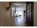 Inviting home hallway featuring wood-look flooring, a bench, dark accent wall, and views into the dining and kitchen at 862 Silverton Springs St, Henderson, NV 89011