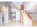 Bright entryway featuring tile flooring, a staircase with wooden banister, and neutral-colored walls at 9021 Feather River Ct, Las Vegas, NV 89117