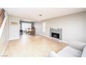 Open-concept living room with fireplace, wood floors, and access to dining area at 9021 Feather River Ct, Las Vegas, NV 89117