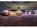 Elegant home exterior with manicured landscaping, and well-lit features for a grand entrance at 9865 Bright Angel Way, Las Vegas, NV 89149
