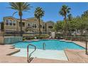 Community pool with a shallow sunbathing area and a waterfall feature for residents at 9975 Peace Way # 1069, Las Vegas, NV 89147