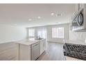 Open-concept kitchen and living area with stainless steel dishwasher and gas range at 1425 Gable Falls Dr # 93, North Las Vegas, NV 89084