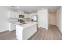 Bright kitchen features white cabinets, stainless steel appliances, quartz countertops, and a center island at 1425 Gable Falls Dr # 93, North Las Vegas, NV 89084