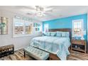 Bright main bedroom with blue accent wall, ceiling fan, and ample natural light at 2225 Chandler Ranch Pl, Laughlin, NV 89029