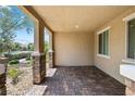 Charming covered patio with brick flooring and stucco walls, perfect for outdoor relaxation at 3188 Via Da Vinci, Henderson, NV 89044