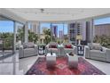 Bright living room with floor to ceiling windows showing palm trees and a city view at 322 Karen Ave # 308, Las Vegas, NV 89109