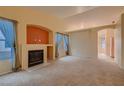 Spacious living room featuring a fireplace, neutral carpet, and light-filled windows at 3426 Side Saddle Ct, North Las Vegas, NV 89032