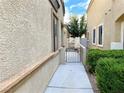 Side yard showcasing walkway leading to gated entry with desert-friendly landscaping at 3809 Van Ness Ave, North Las Vegas, NV 89081