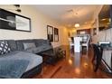 Open floor plan showcasing the wood floors, a gray sectional couch, and views of the dining and kitchen areas at 4585 Dean Martin Dr # 205, Las Vegas, NV 89103